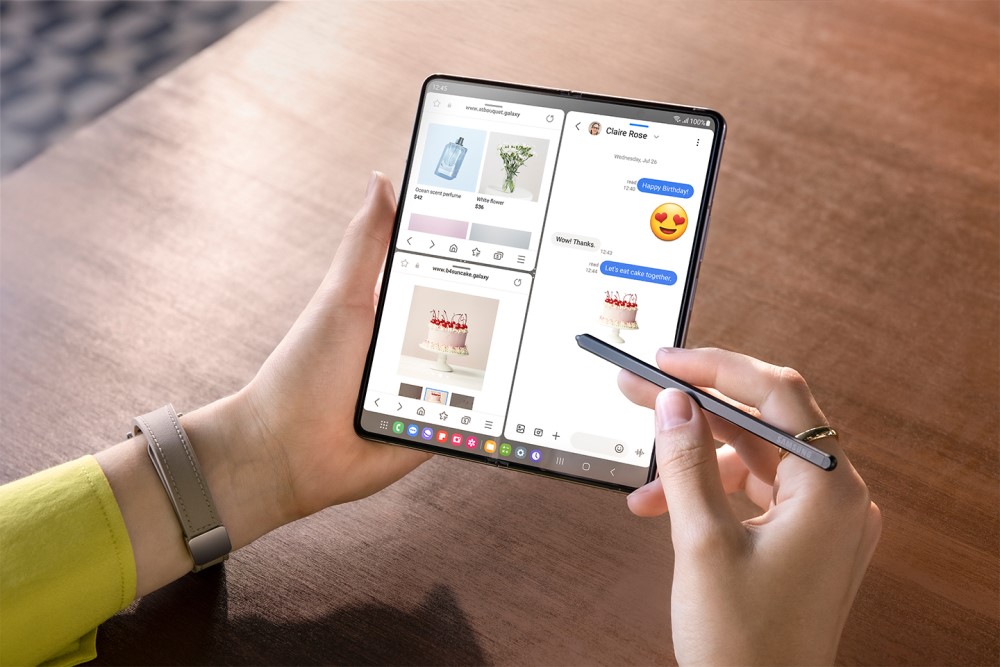 Photo of a person using a Samsung Galaxy Z Fold5 to multitask chat and photo editing.